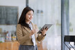 © SOMKID - Young asian businesswoman using tablet to startup projects and business presentation plan.