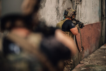 Canvas Print - Group of air soft players in action attacking opponent in crashed building