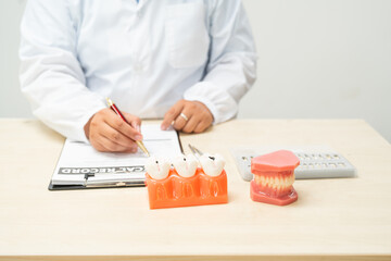  A female doctor sits at a table in a hospital, discussing dental issues like wisdom teeth, cavities, dentures,missing teeth, and cracked teeth, explaining the causes and treatment of dental caries.