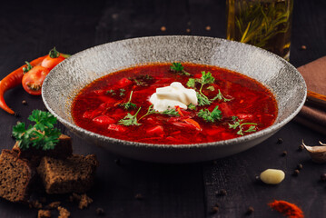 Steaming hot bowl of borscht with sour cream and parsley