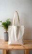 © Ehtisham - A blank white canvas tote bag sits on a wooden table. ready for your design or logo.