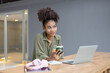 © SOMKID - About successful young woman concept. Excited African American woman sitting at working desk.