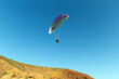 © Alexey Tkachenko  - Paragliding against the backdrop of blue sky and red mountains