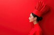 © talkative.studio - Woman in Red Chef's Hat and Uniform Against Red Background