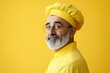 © talkative.studio - A man in a yellow chef hat and uniform smiles against a yellow background.