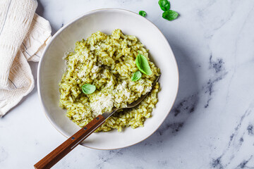 Green pesto risotto with parmesan, white background.