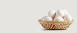 © StockKing - Fresh chicken eggs stacked in a bamboo wicker basket isolated on a white background with space for text Ideal for food and nutrition ads. with copyspace image