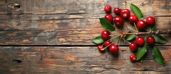 Wall Mural - Fresh ripe cherries with leaves on a textured wooden background Copy space image ideal for displays of vegan healthy eating options