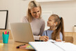© Westend61 - Girl doing homework with mother at home