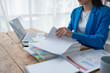© Jirapong - woman plans a finance and budget audit by reviewing organizing office financial documents