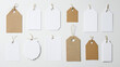 © Elmin - A variety of blank white paper labels and cloth tags isolated on a white background, ideal for price tag mockups with space for branding and information.