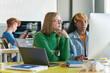 © Mediaphotos - Girls sitting at desk with computers during IT class in school or college and writing code