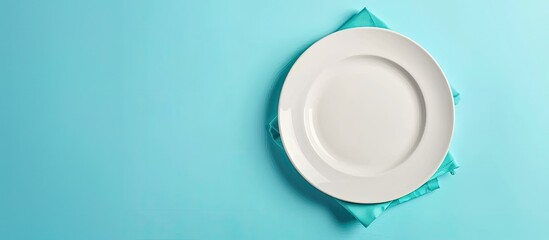 Poster - White porcelain plate on linen cover with a blue background perfect for food styling in a flat lay copy space image
