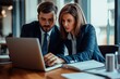 © yj - Two busy professional executives team using laptop in modern office. Business man and woman leaders managers working on computer at work desk having conversation on financial project at meeting.