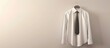 © HN Works - Shirt and necktie on hanger against a light wall with copy space image