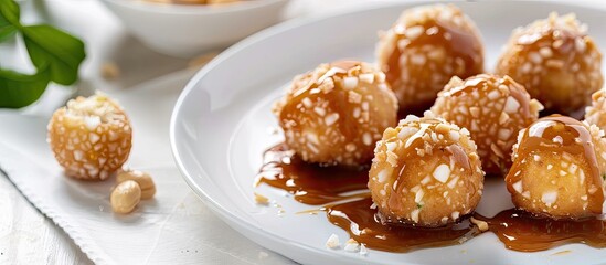 Sticker - Cilok tapioca and flour balls drizzled with peanut sauce presented on a white plate with copy space image