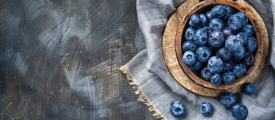 Canvas Print - Top view close up of blueberries displayed on a wooden plate against a rustic cloth background with a blank space for text in the image. Creative banner. Copyspace image