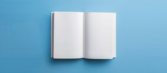 Poster - Top down flat lay of an open blank white book on a blue desk with copy space image