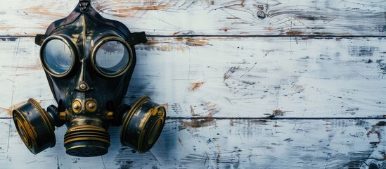 Top down photo of a gas mask on a white wood backdrop providing a copy space image for text