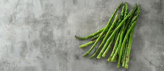 Canvas Print - Top view of fresh asparagus displayed on a concrete background with a copyspace image