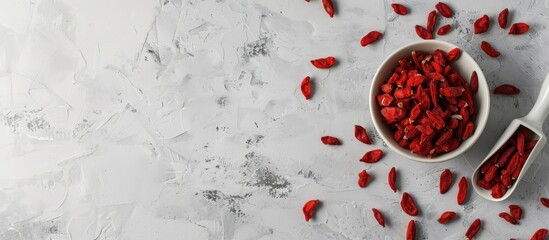 Aufkleber - Top view of a light grey table with a bowl of dried goji berries accompanied by a scoop suitable for adding text with copy space image