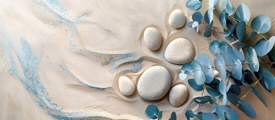 Poster - Minimalistic background with round rock stones blue eucalyptus branches and beige sand ideal for product presentations with copy space image