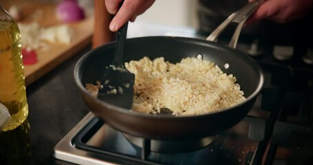 Canvas Print - Cooking, stirring and hand of man in kitchen for recipe, culinary skills and pan on stove. Chef, healthy food and rice in skillet for preparation, risotto process or private class in home for cuisine