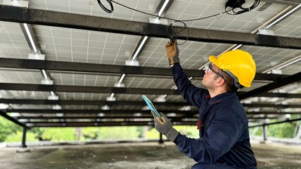 Technical engineer Inspecting the installation of the solar panels and checking the integrity of all wires connected to the solar panels. for the system to work properly