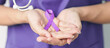 © Jo Panuwat D - Doctor holding purple Ribbon for Violence, Pancreatic, Esophageal, Testicular cancer, Alzheimer, epilepsy, lupus, Sarcoidosis and Fibromyalgia. Awareness month and World cancer day concept