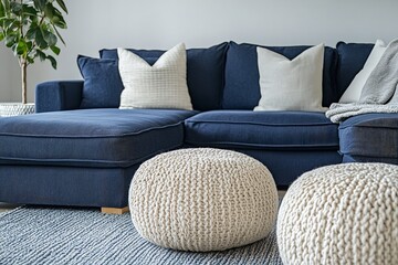 Two knitted poufs positioned near a dark blue corner sofa, showcasing a Scandinavian design in the modern living room.