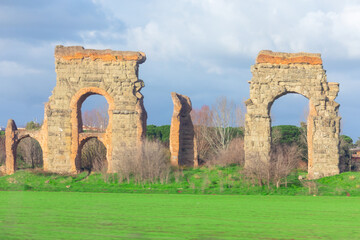 Wall Mural - Roman aqueducts in Rome. Ancient Roman ruins and stone monuments at Via Appia Antica