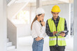 © KMPZZZ - Builder team, foreman asian young engineer, architect man, woman working, discussing construction drawing on clipboard follow project to build industrial plan at house site. Engineering worker people.