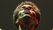 © Andrea Marongiu - Young man of african descent with curly hair is illuminated on his face in the dark. Poster and wallpaper with victory image and liberating and dramatic expression of sportsman who won a race