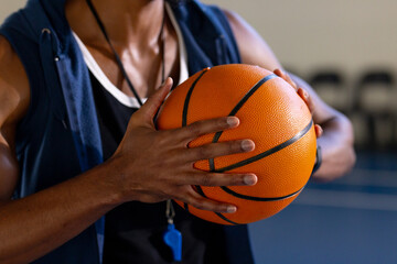 Wall Mural - Holding basketball, coach with whistle preparing for practice session in gym