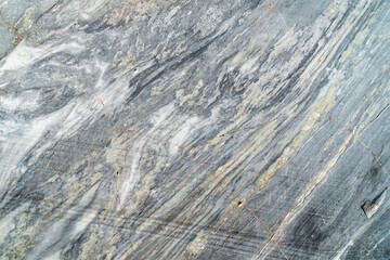 Natural grey marble stone texture, not polished. Surface of marble slab with striped streaks and cracks.