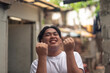 © Mdv Edwards - An elated young man looking up feeling overjoyed. Eyes closed feeling blissful. A local person living in an squatter area. Slum area background.