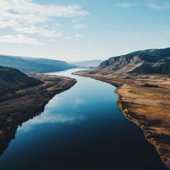 Canvas Print - A winding river meanders through a valley, surrounded by hills and grasslands.