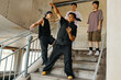 © DragonImages - Group of dancers practicing movements under urban overpass, showcasing dynamic poses and expressions. Composition includes three men and one woman on stairs