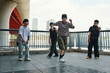 © DragonImages - Group of young men performing energetic dance routine under urban bridge background Sturdy bridge structure visible while dancers showcase vibrant moves in laid-back attire