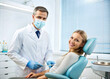 © Selena Moore - Male dentist with happy female patient in modern dentistry. Dentistry advertisement