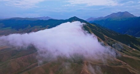 Wall Mural - Aerial view of white clouds and mountains natural landscape at dusk in Xinjiang, China. Beautiful mountain range scenery in summer.