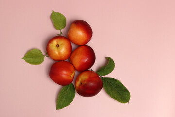 Poster - Ripe nectarines on a pink background with copy space. Flat lay, top view of fresh fruit on a table. Healthy eating concept. 