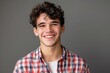 © sakuratanaka - Close up portrait of cheerful young man in checkered shirt.