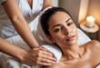 © natakot - A woman enjoying a peaceful massage in a candle-lit spa, focusing on wellness and relaxation.