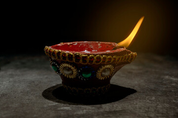 Sticker - A red and gold decorated pot with a blue and white design sits on a dark surface