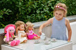 © Irina Schmidt - Little preschool girl playing with dolls. Happy excited child play tea party with toys. Role games for children, activity for one person. Role game for small children.