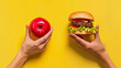 © picsmart - Burger and apple in both hands food comparison concept