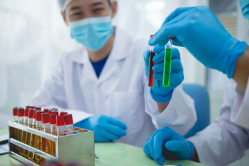 In this chemical experiment, two researchers collaborate to mix reactants, carefully observe changes such as color shifts or gas production, and analyze results, demonstrating principles of chemistry