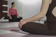 © ninelutsk - Yoga teacher guides meditation session in a serene studio filled with natural light. Participants engage in mindfulness practice, promoting relaxation and inner peace