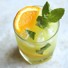 Sticker - Refreshing green drink in a glass with orange slice and mint garnish.